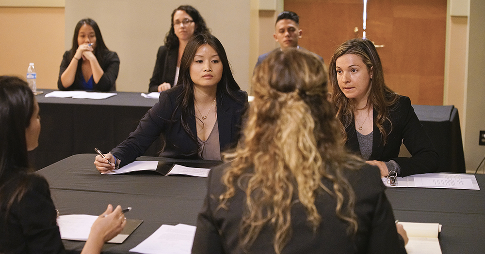 Negotiation competition with Professor Knolton in background Thumbnail