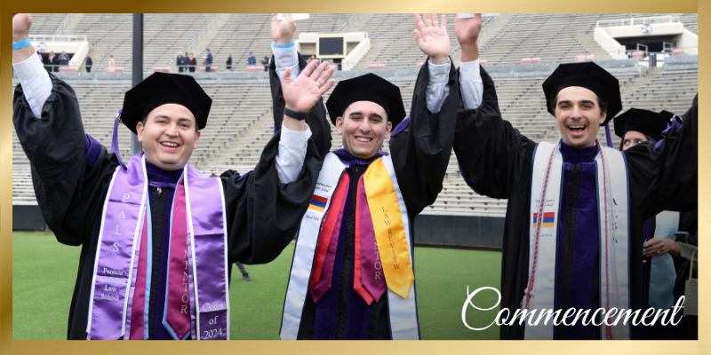 Three Southwestern graduates waving their arms in the air