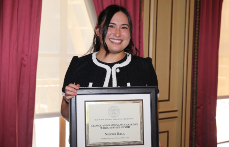 Nikki Bala holding her Woolverton Award certificate