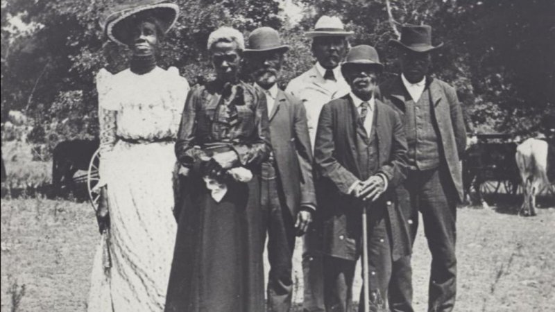 Four African Americans dressed up for an Emancipation Day celebration, June 19, 1900 held in "East Woods" on East 24th Street in Austin. Credit: Austin History Center.