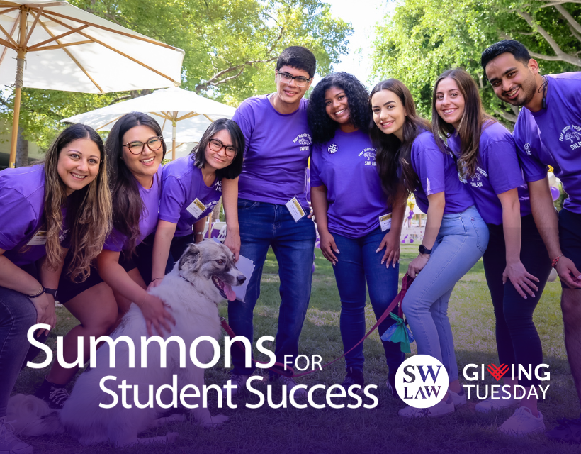 Group of Southwestern students in purple peer mentor shirts at Orientation petting a dog