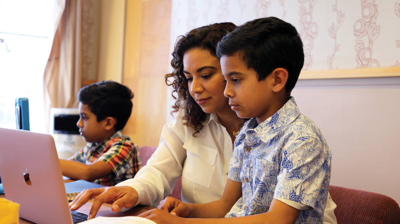 Student with her two children at laptop