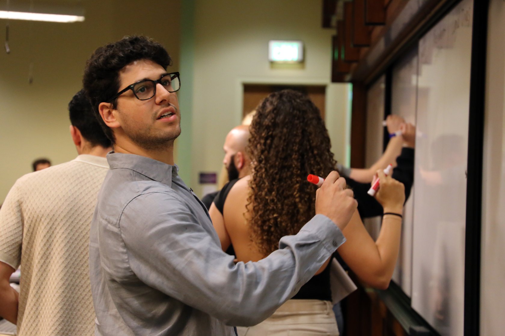 SCALE student writing on whiteboard in classroom
