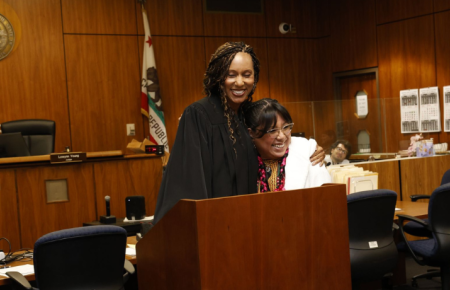 Ester Mendez hugging judge at her bar pass swearing in ceremony in courtroom